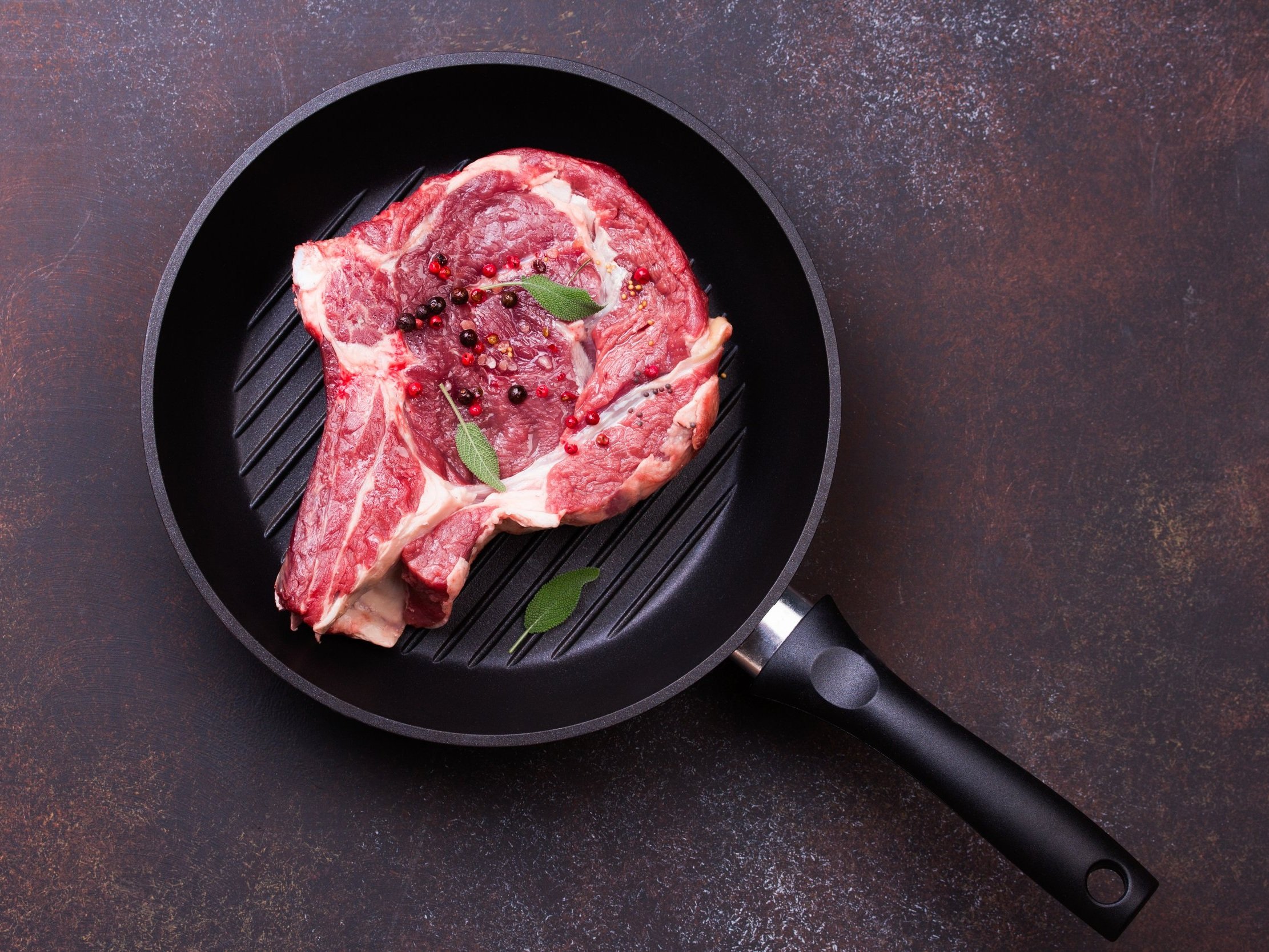 Juicy, medium-rare steak being sliced on a wooden cutting board, showcasing its tender pink interior and seared crust, with a carving knife and fork positioned for serving.