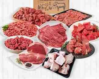 Juicy, medium-rare steak being sliced on a wooden cutting board, showcasing its tender pink interior and seared crust, with a carving knife and fork positioned for serving.